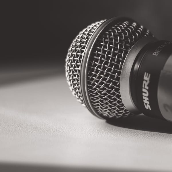 Artistic close-up of a Shure microphone in black and white, showcasing intricate details.