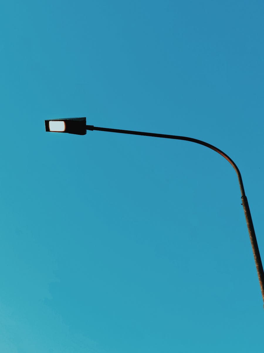 Simple streetlight against a clear blue sky, representing minimalism and urban serenity.